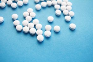 White pills scattered on a blue background