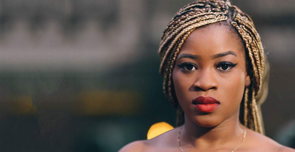 Woman with braided hair looking forward while considering pregnancy options PRC Grand Rapids.