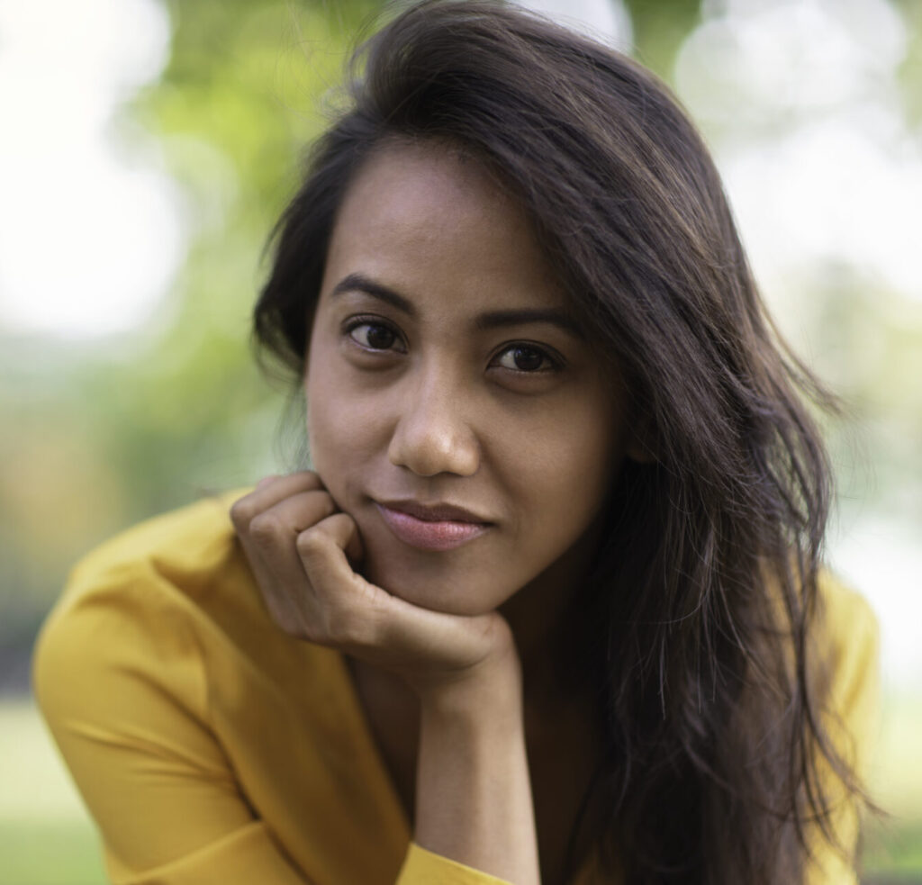 Woman resting her chin on her hand while thinking through pregnancy options.