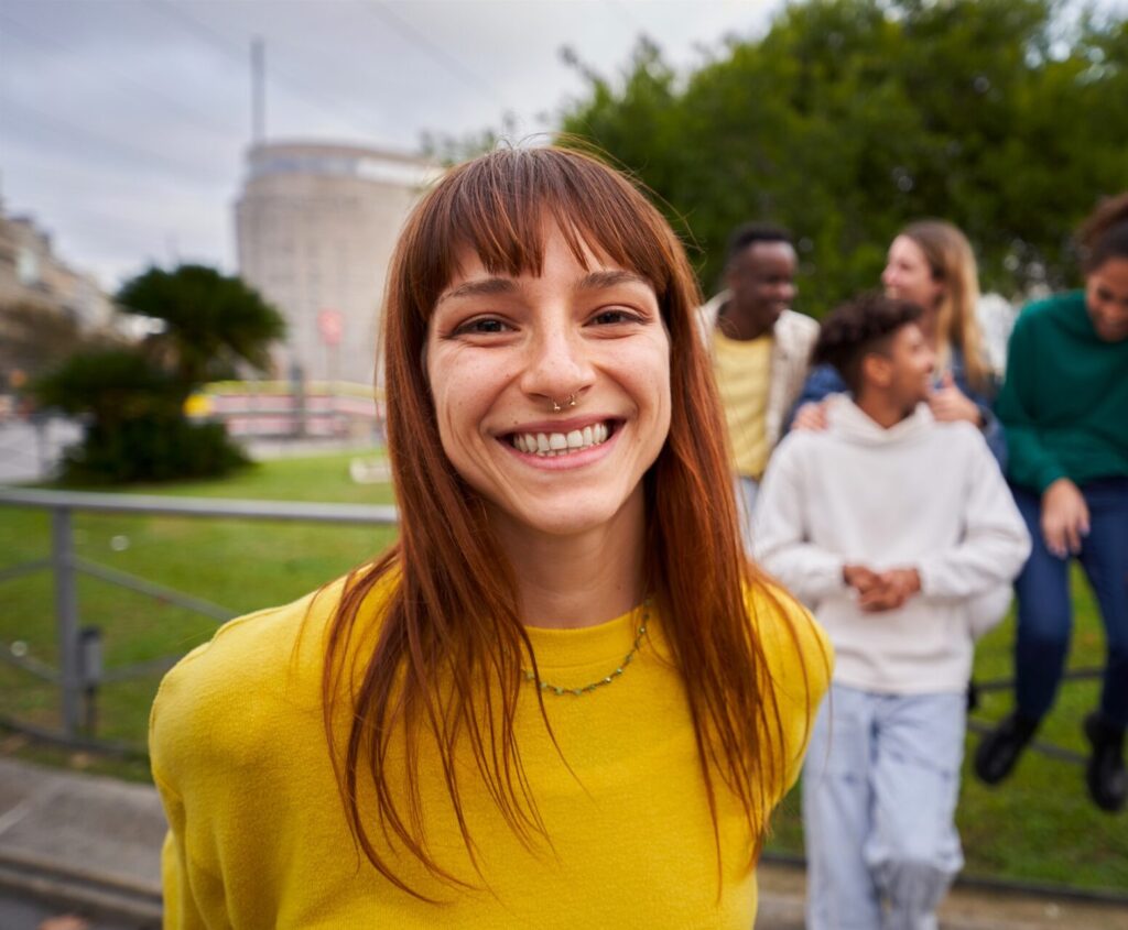 Young woman smiling outdoors while feeling encouraged by pregnancy support services.
