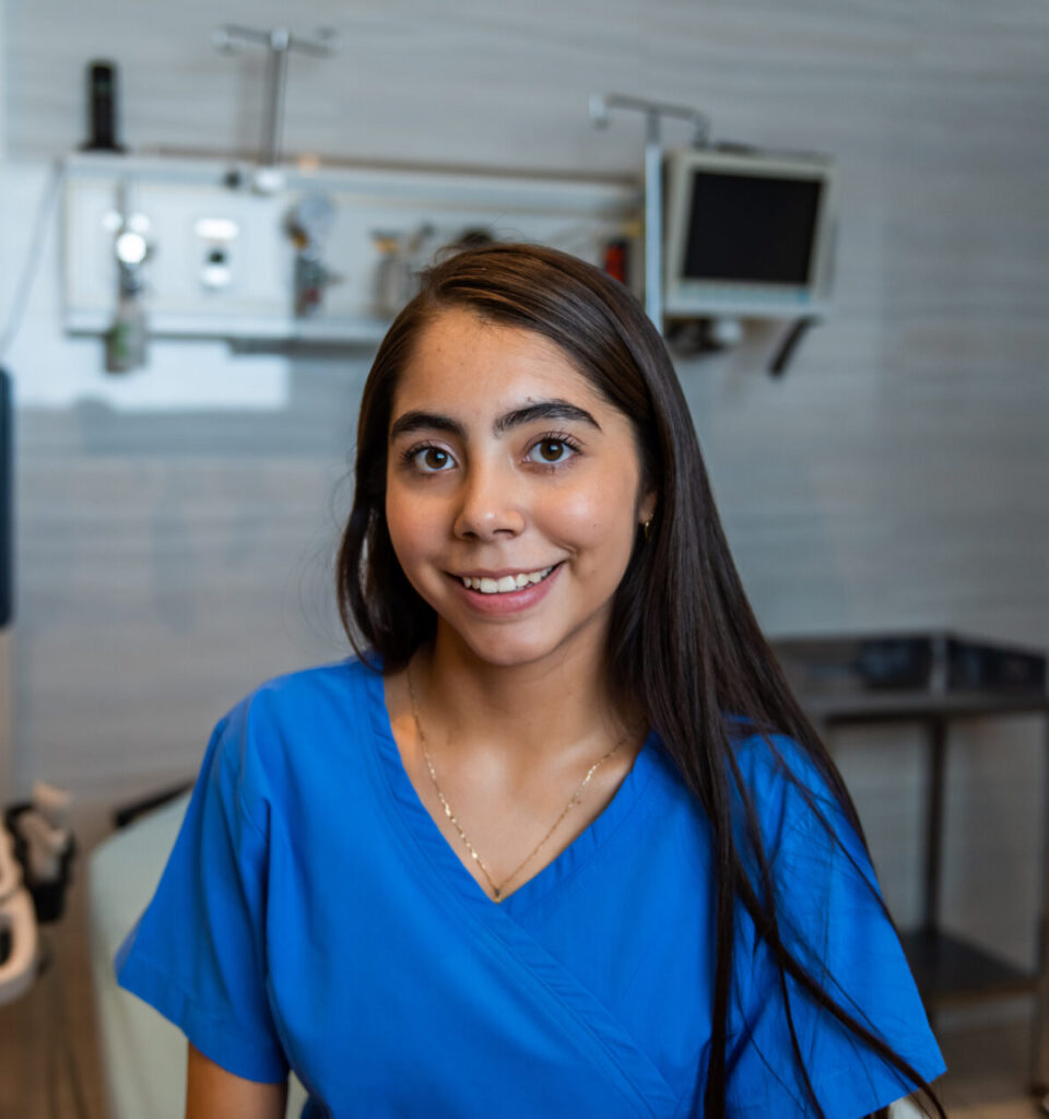 Medical staff member smiling while welcoming a client for pregnancy services at PRC Grand Rapids.