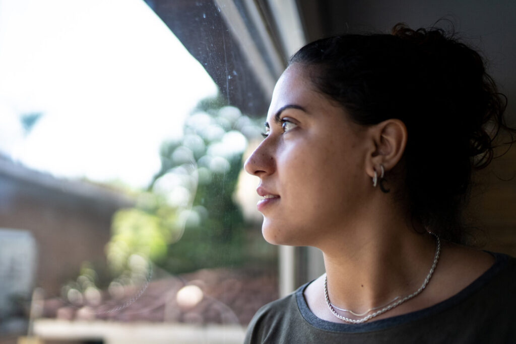 Woman looking thoughtfully at her pregnancy plan outdoors.