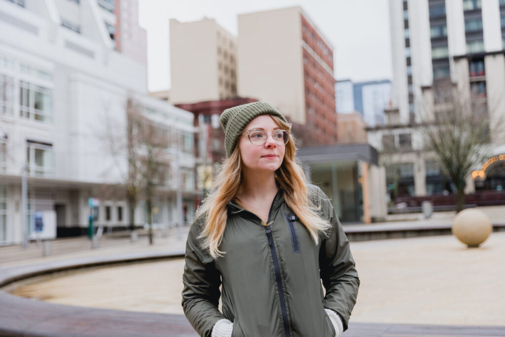 Woman standing outdoors, planning for her pregnancy.